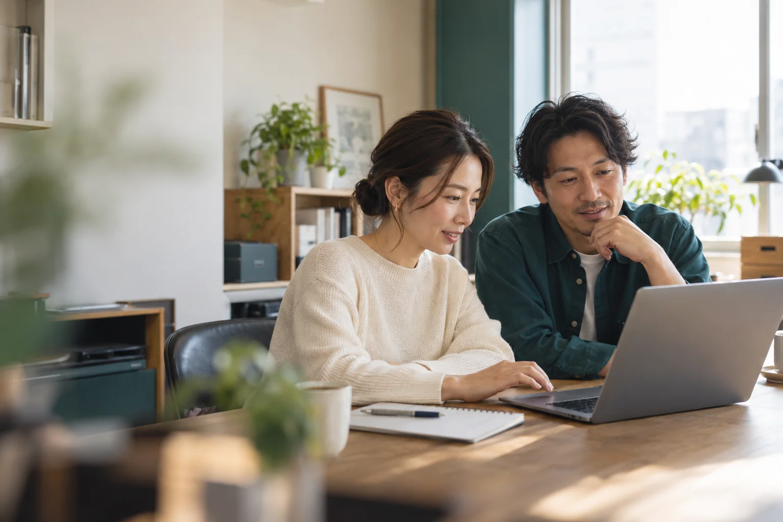 明るいオフィスで、二人の担当者がパソコンを見ながらウェブサイトの変更内容を一緒に確認するイメージ